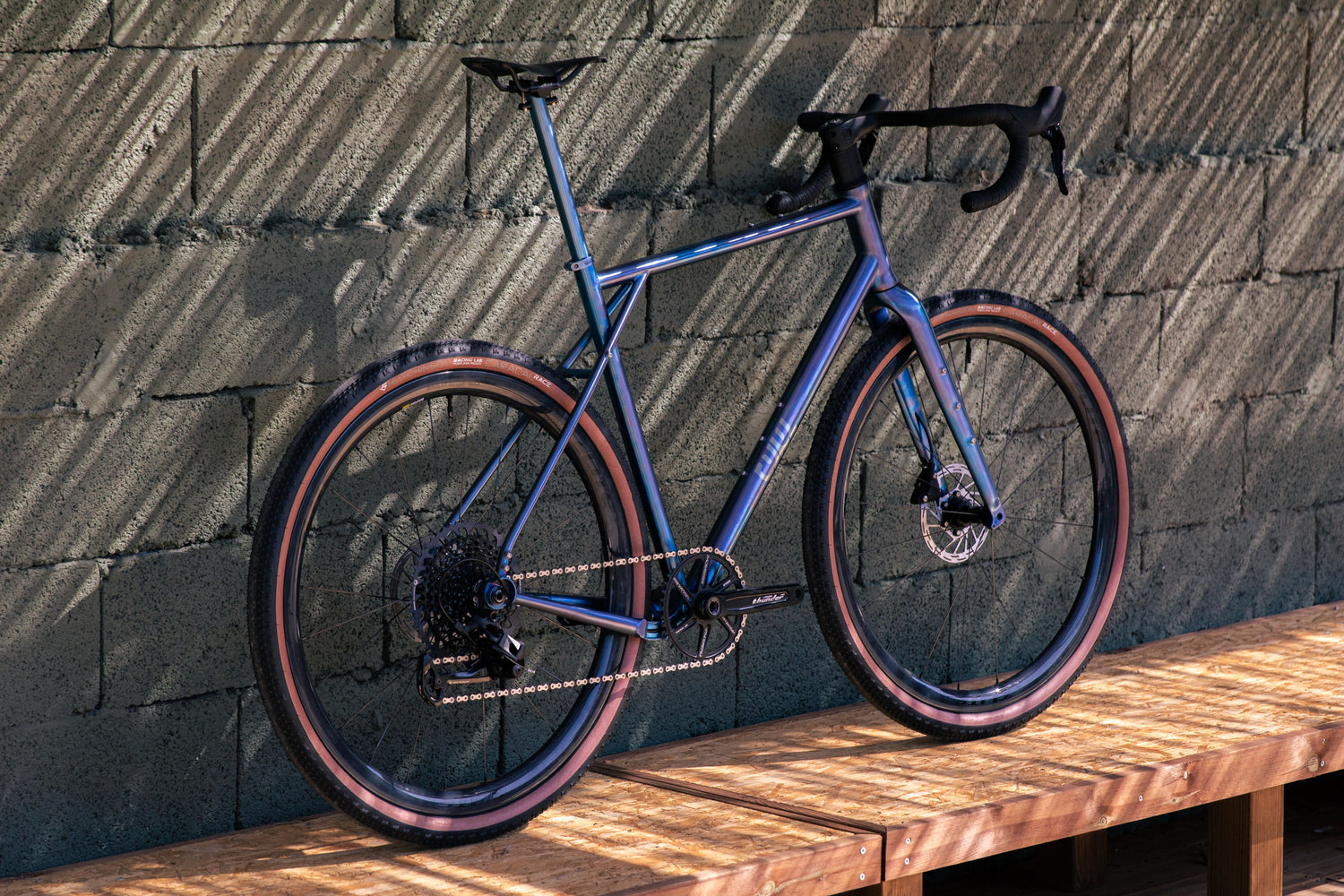 Vélo gravel en titane CYKL GRAAVE personnalisé bleu anodisé, configuré pour le bikepacking et la performance.