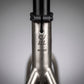 Détail du tube de selle en titane brossé du CYKL MONO, montrant le marquage gravé et l'indicateur de taille L, illustrant la finition minérale du Grade 9.