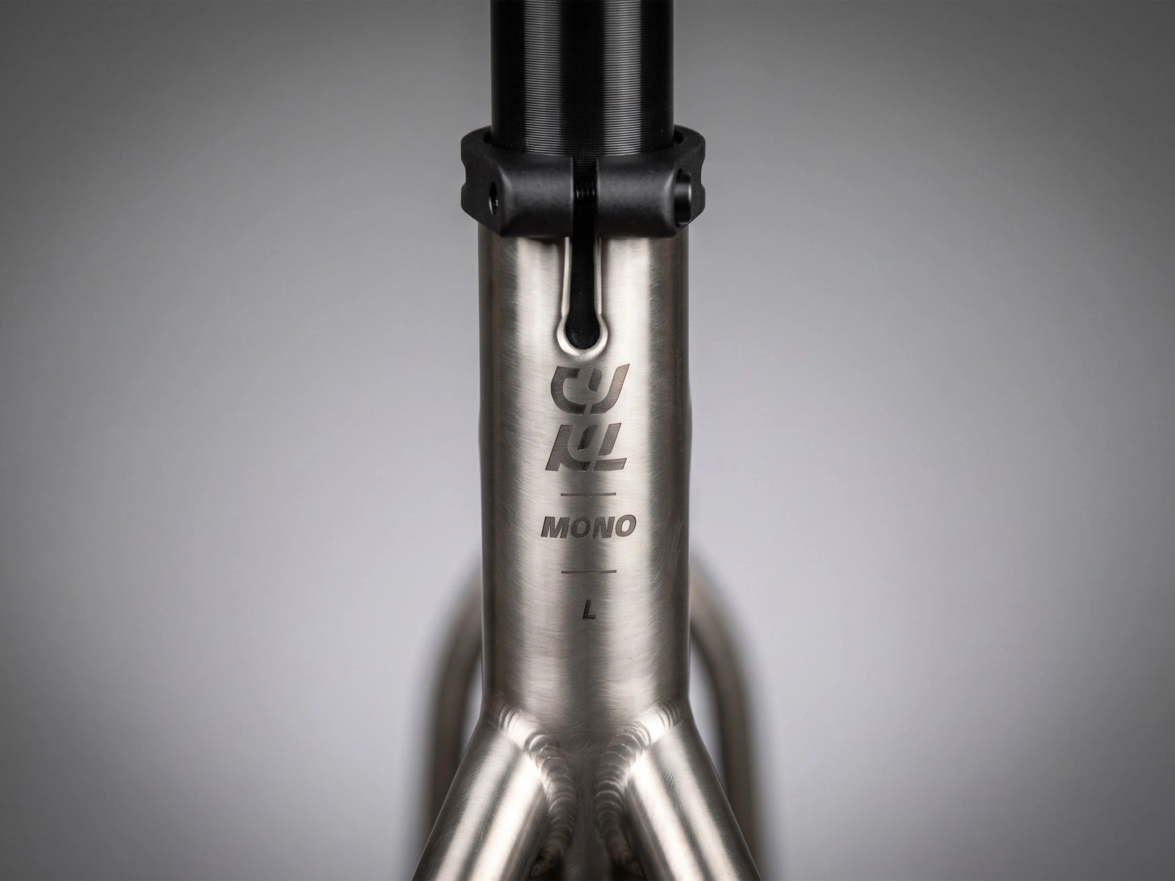 Détail du tube de selle en titane brossé du CYKL MONO, montrant le marquage gravé et l'indicateur de taille L, illustrant la finition minérale du Grade 9.