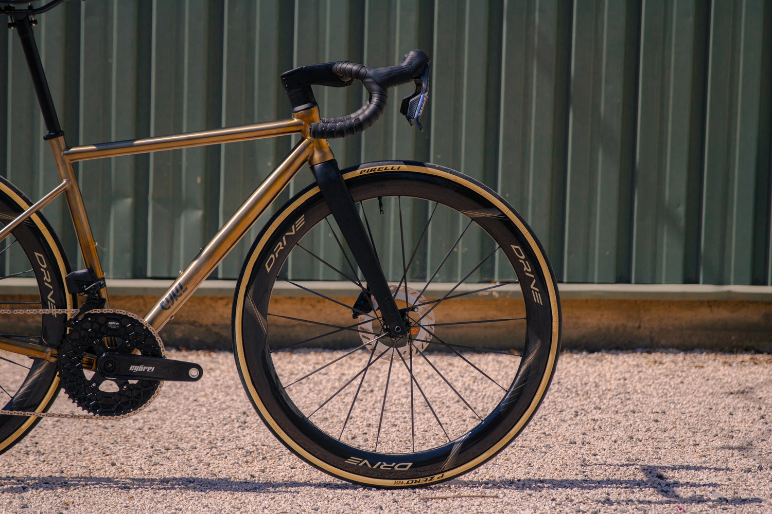 Avant du cadre CYKL SWIIFT titane montrant la fourche carbone sans œillets et la roue avant Elitewheels Drive 50D.