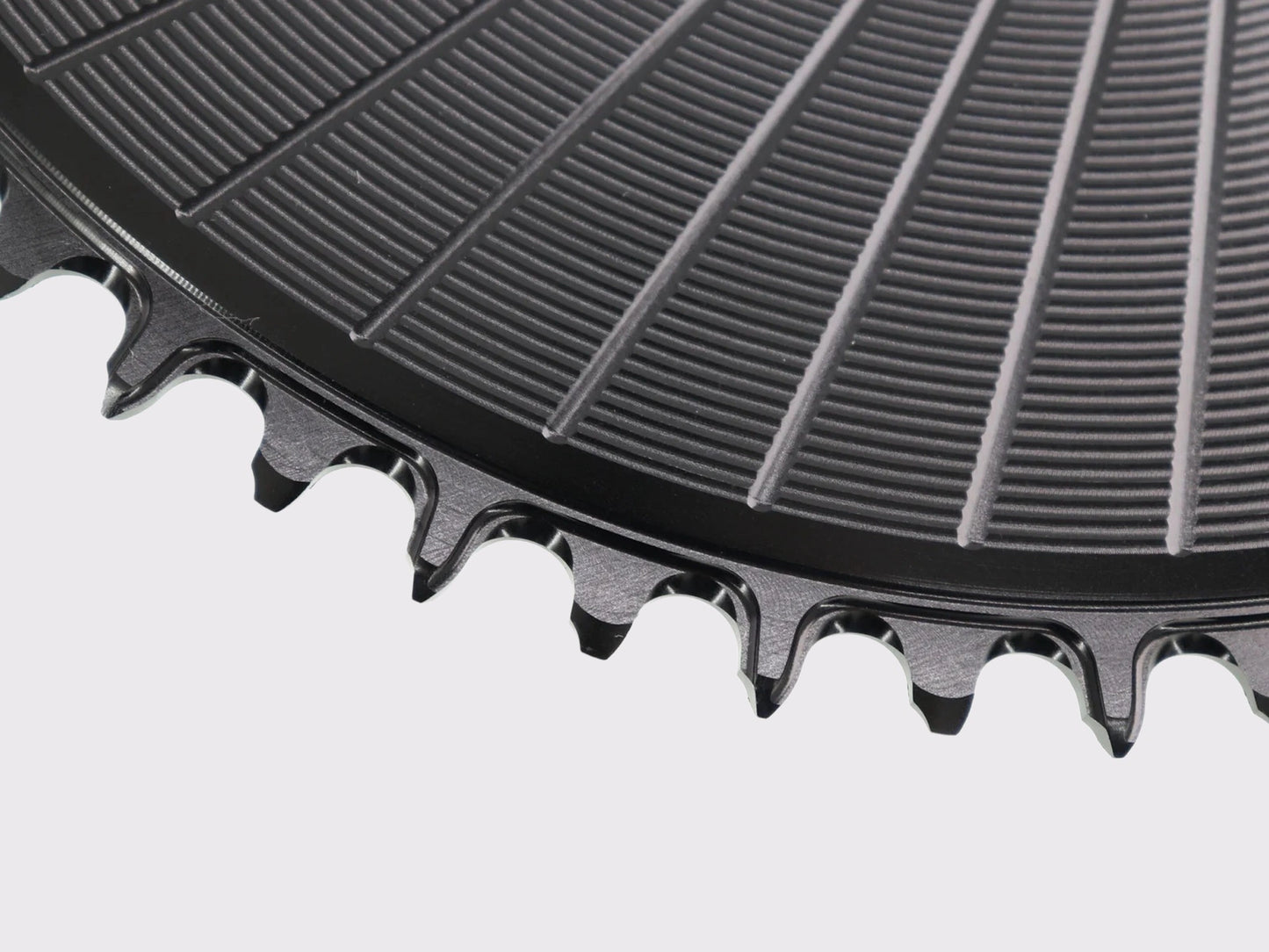 Macro sur l'usinage CNC de précision des dents narrow-wide du plateau Stone Aero noir, fini texturé de la surface en aluminium.