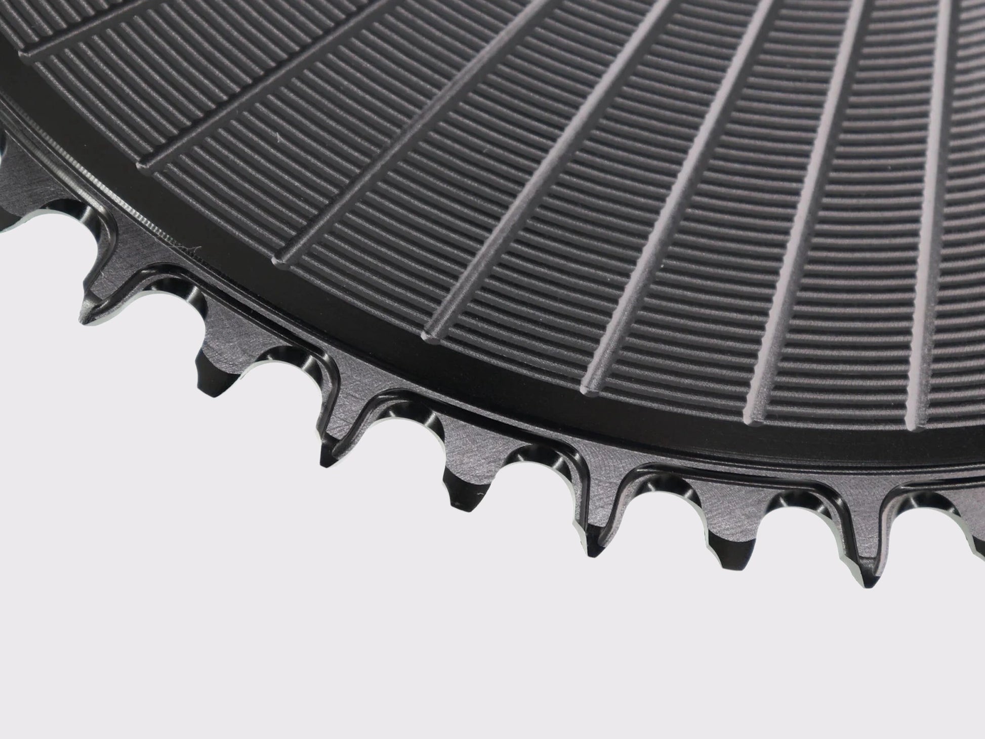 Macro sur l'usinage CNC de précision des dents narrow-wide du plateau Stone Aero noir, fini texturé de la surface en aluminium.