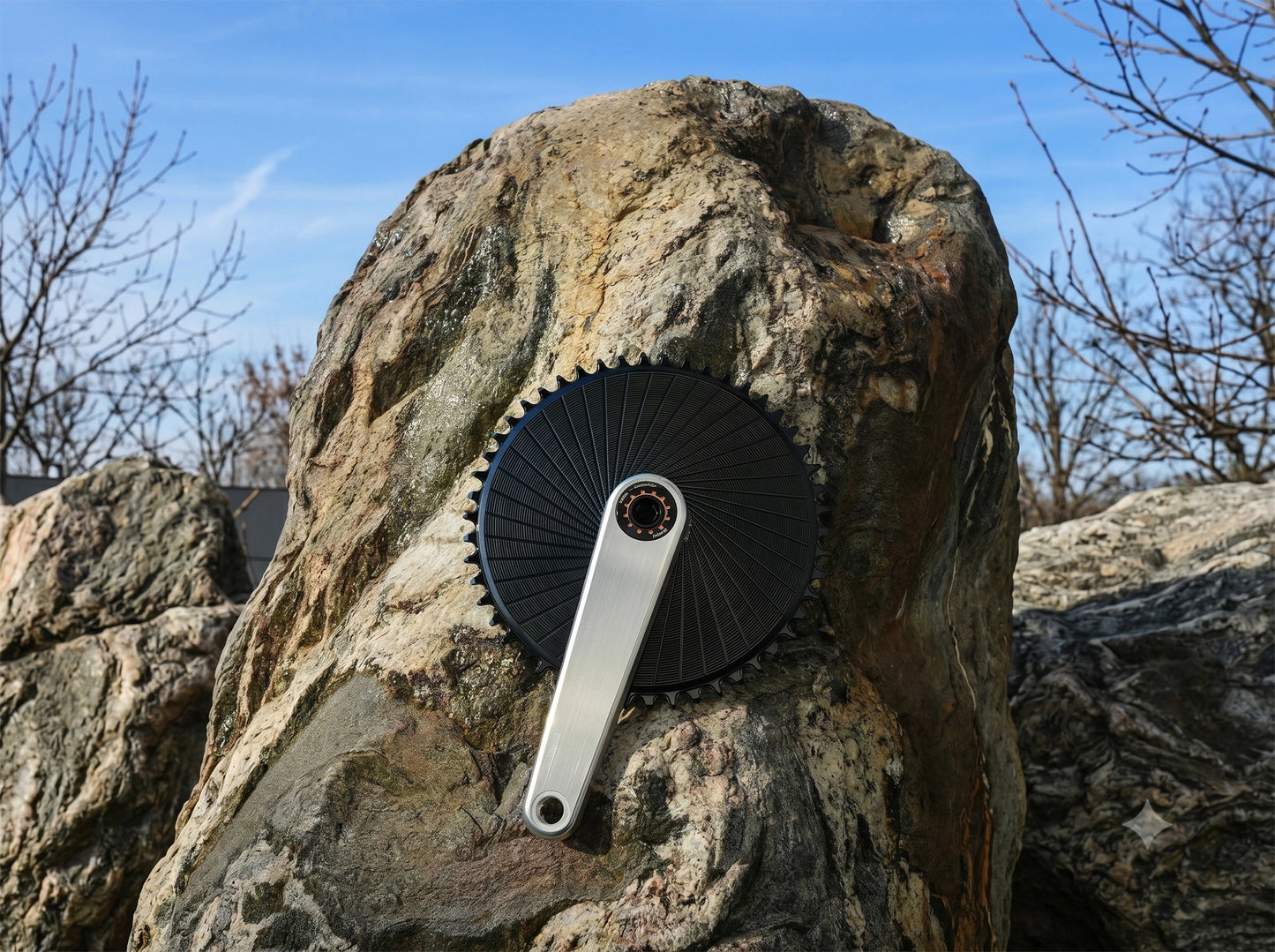 Manivelle Stone en aluminium brut brossé montée avec un grand plateau aéro noir sur fond minéral