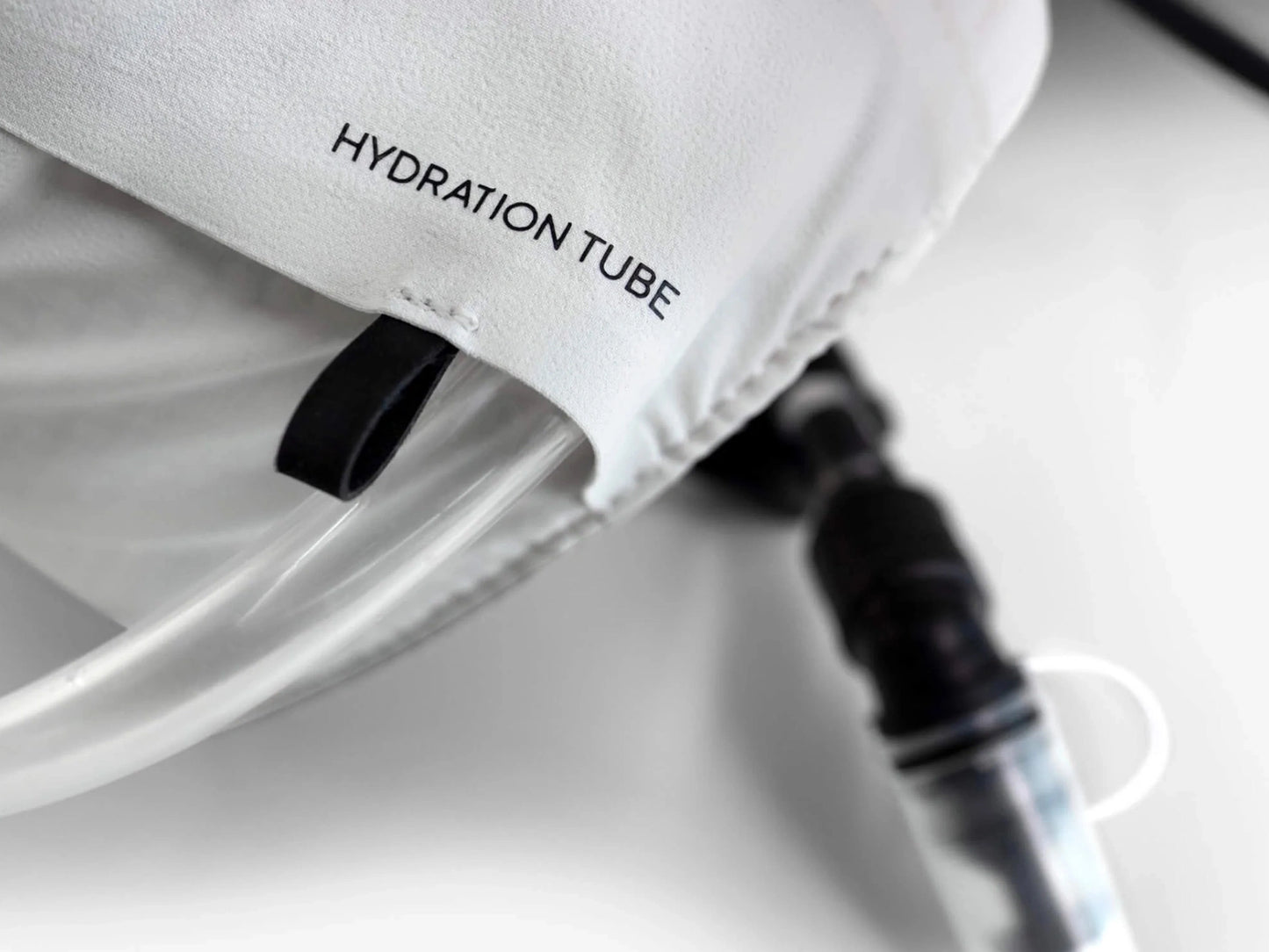 Détail technique du passage de guidage Hydration Tube sur la bretelle du gilet Cyclite Hydration Vest 01 blanc.