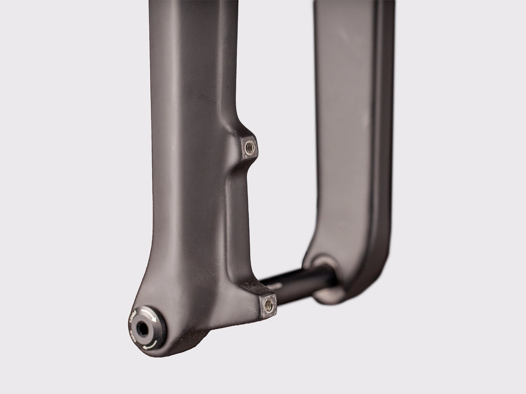 Gros plan sur l'interface de l'axe traversant et les supports de fixation du frein. Détail de l'exécution de l'insert interchangeable en aluminium usiné.