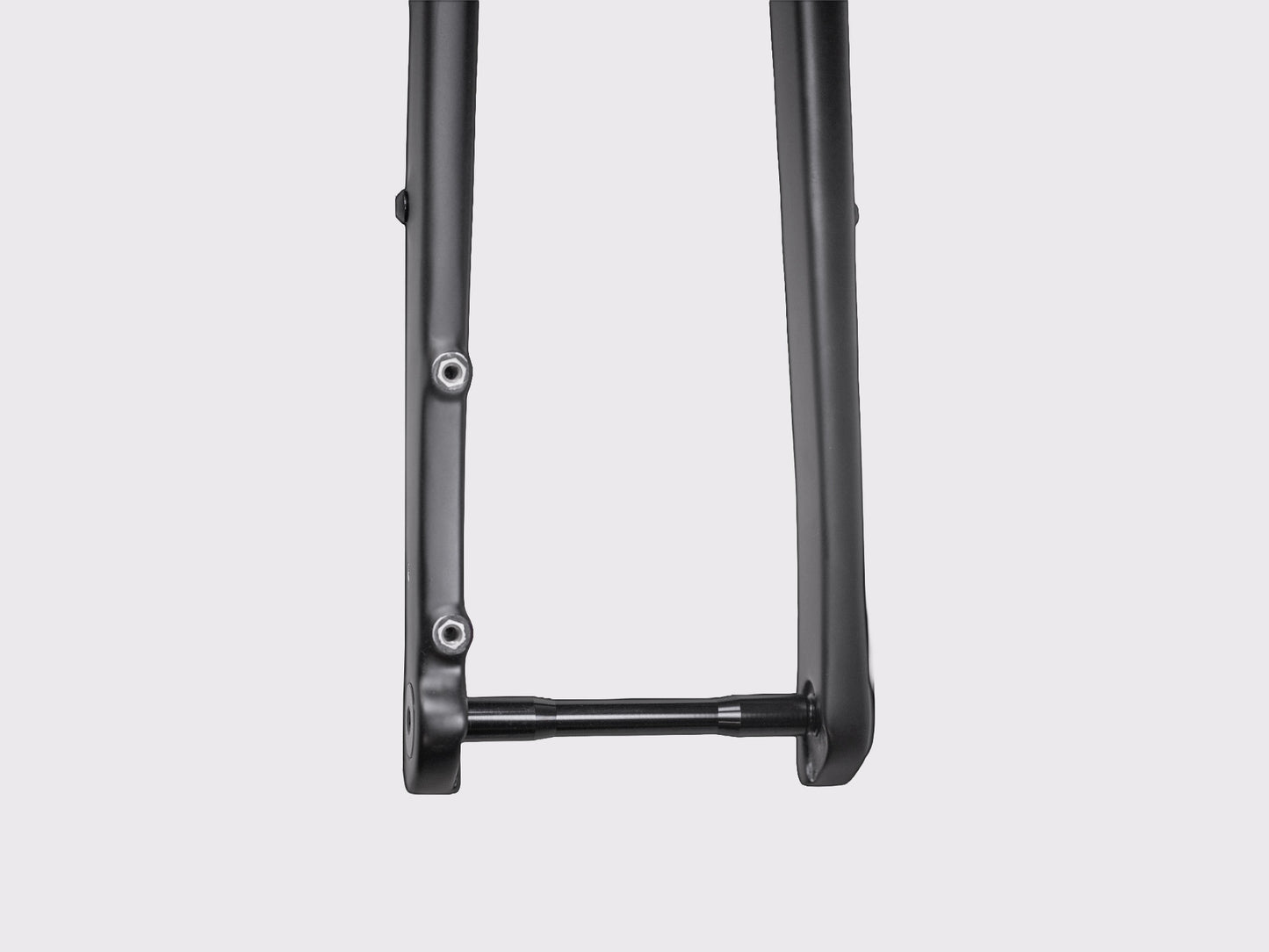 Détail macro sur la patte de fourche inférieure montrant l'interface de l'axe traversant et les deux inserts filetés inférieurs pour accessoires.