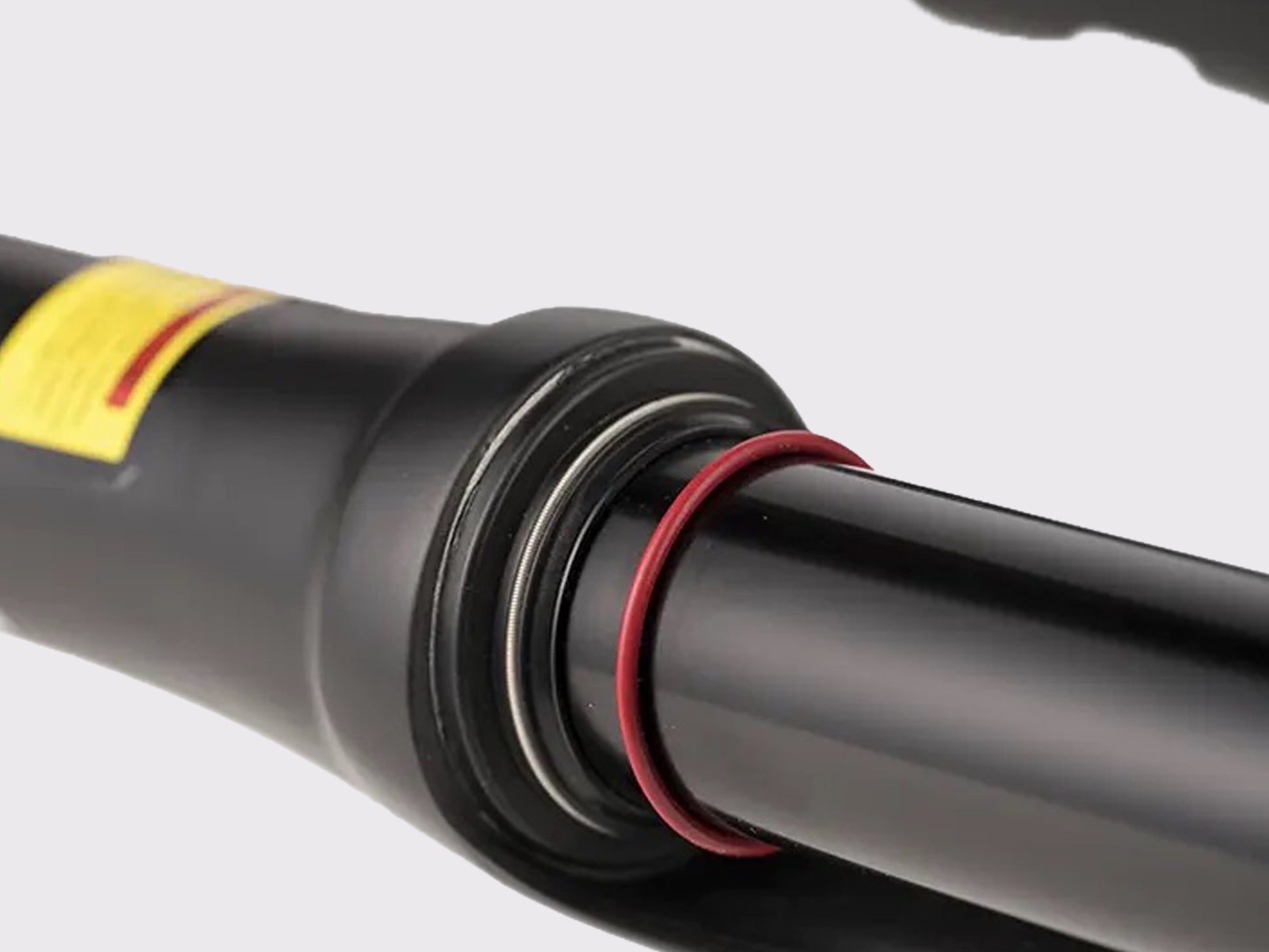 Détail de l'interface plongeur-fourreau affichant le joint racleur haute performance et l'anneau témoin de débattement (O-ring) pour le réglage du SAG.