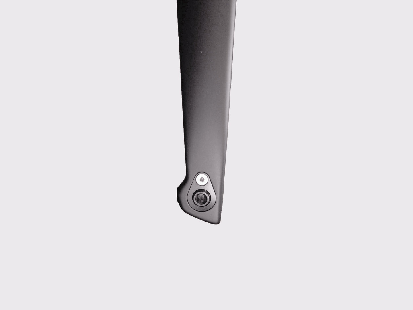 Vue macro de l'œillet en titane intégré dans le drapage carbone. Interface précise pour la fixation d'accessoires sans altération structurelle.