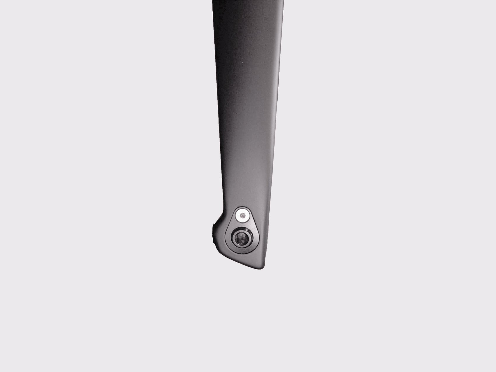 Vue macro de l'œillet en titane intégré dans le drapage carbone. Interface précise pour la fixation d'accessoires sans altération structurelle.