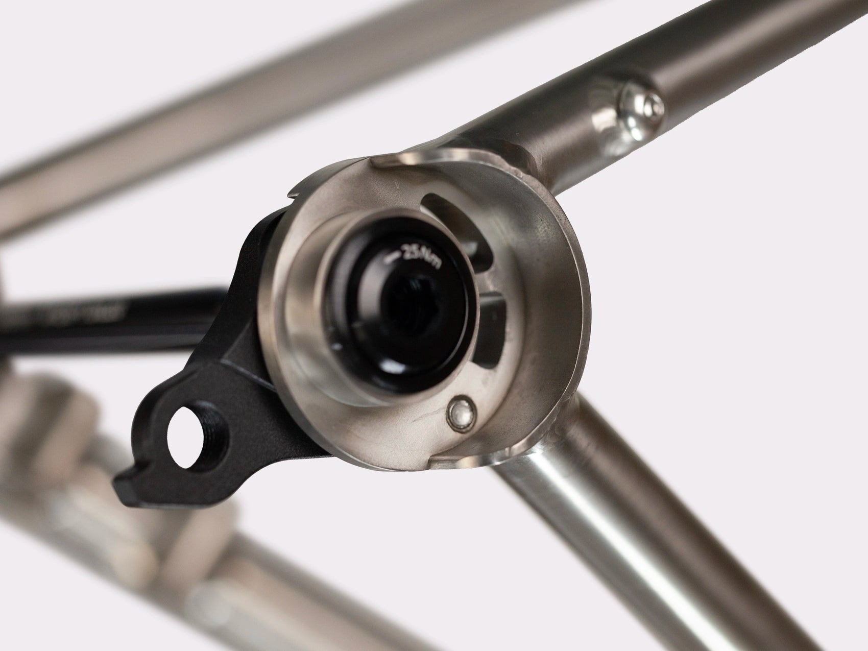Cadre gravel titane CYKL MONO. Vue sur la patte dérailleur UDH et l'axe traversant.