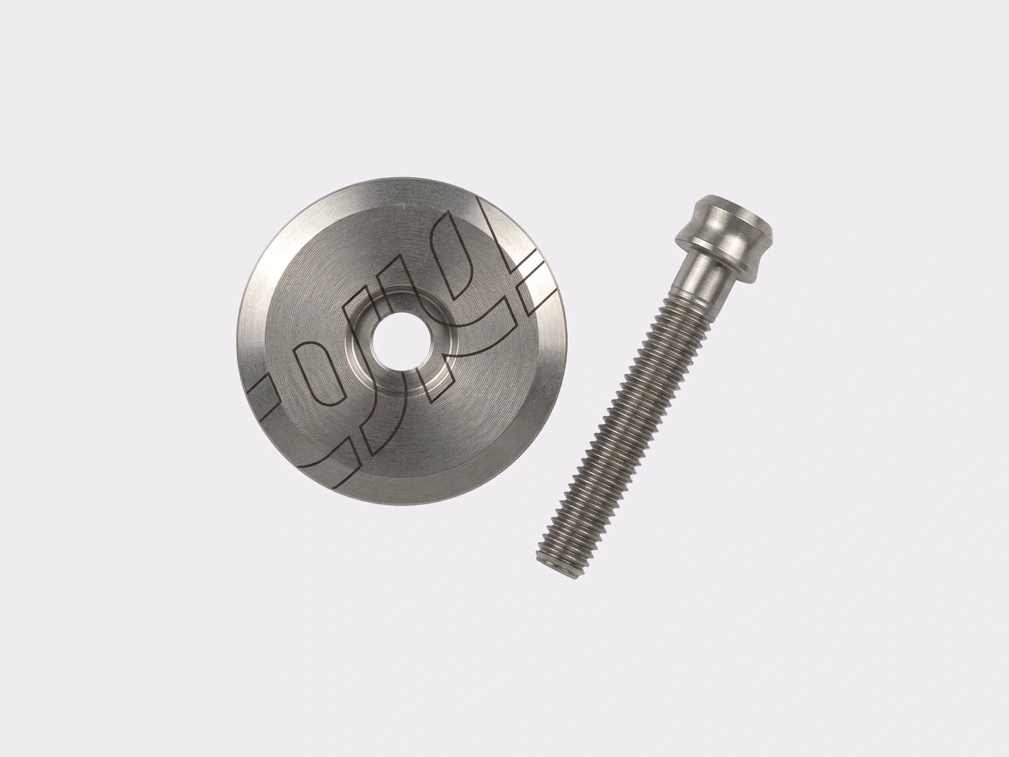 Bouchon de potence CYKL en titane brut et sa vis de serrage, installés sur une potence de vélo. (Brut titane)
