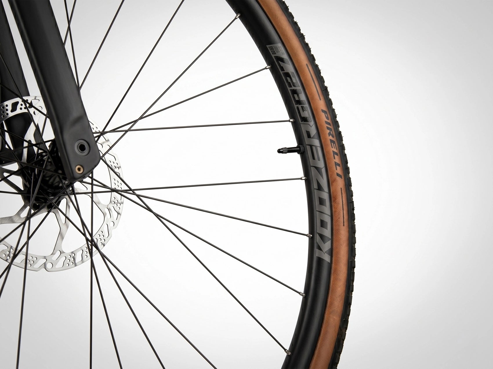 Vue détaillée du moyeu Koozer à système ratchet et rayons profilés montés sur une roue aluminium avec pneu Pirelli pour le gravel CYKL MONO.